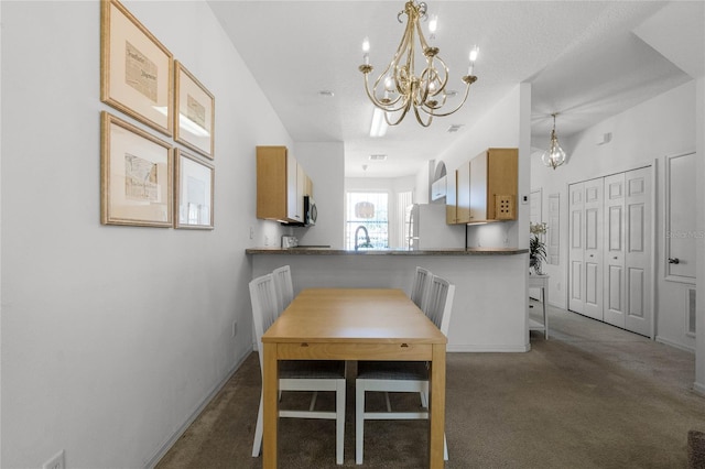 dining area with an inviting chandelier, sink, and dark colored carpet