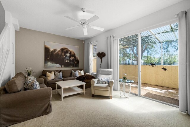 carpeted living room with ceiling fan