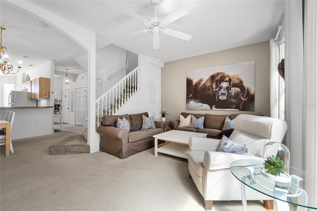 1256 S Beach Cir, Kissimmee, FL 34746 - living room with light carpet, ceiling fan with notable chandelier, and stairs