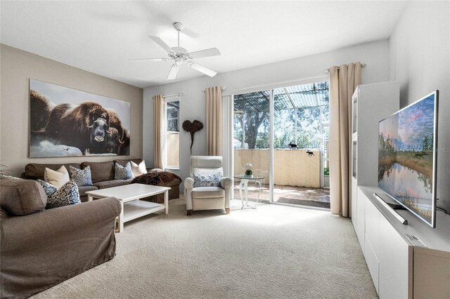 carpeted living room with ceiling fan