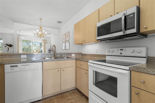 kitchen featuring ceiling fan with notable chandelier, white appliances, light brown cabinetry, dark tile patterned floors, and sink