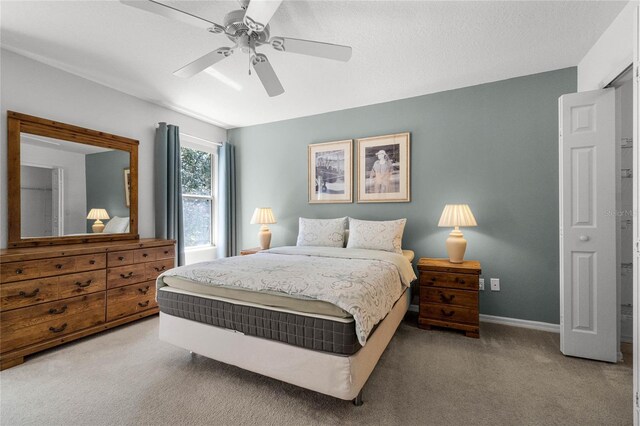 bedroom featuring ceiling fan, a textured ceiling, and light carpet