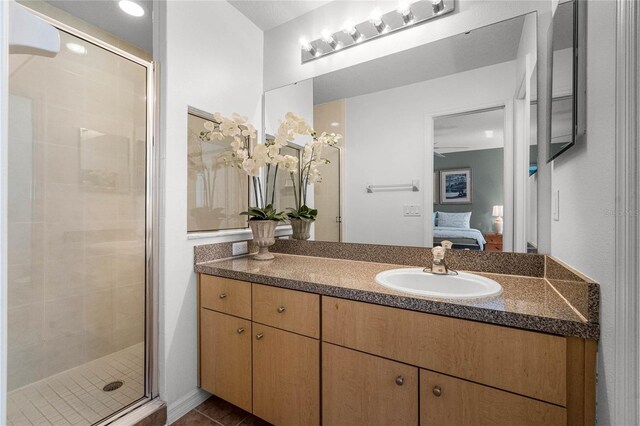 bathroom featuring vanity, a shower with shower door, and tile patterned floors