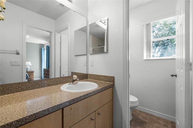 bathroom with vanity, toilet, and tile patterned floors