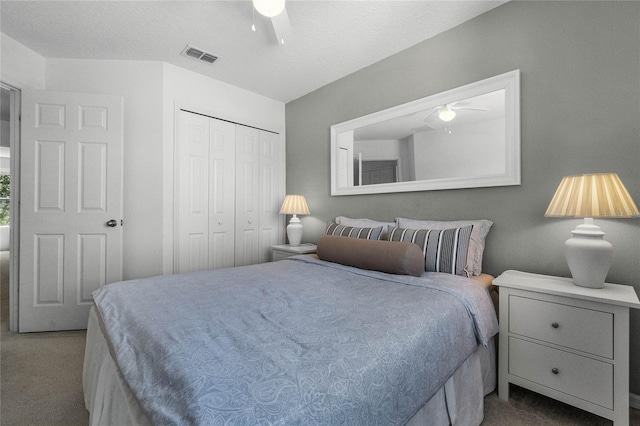 carpeted bedroom featuring a closet, ceiling fan, and a textured ceiling