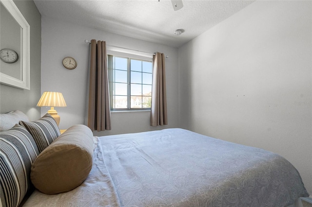 bedroom featuring ceiling fan and a textured ceiling