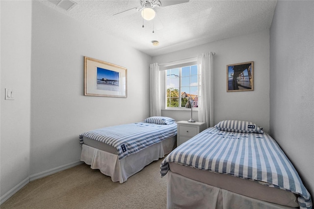 carpeted bedroom with ceiling fan and a textured ceiling