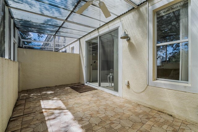 unfurnished sunroom with ceiling fan