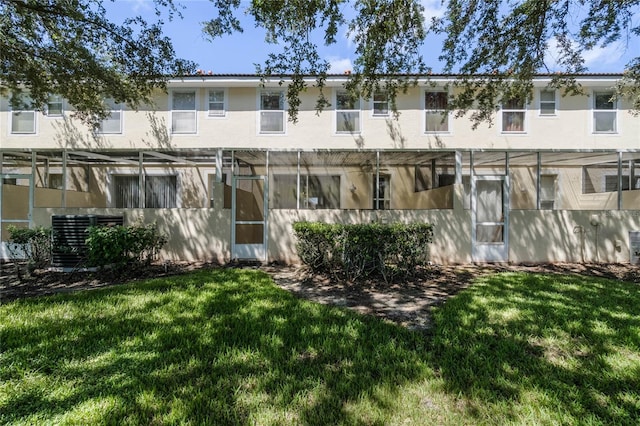 rear view of property with a yard and central AC