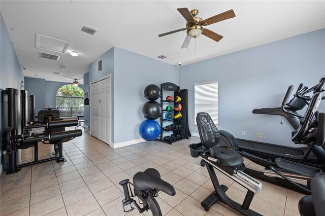 workout room featuring ceiling fan and light tile patterned flooring