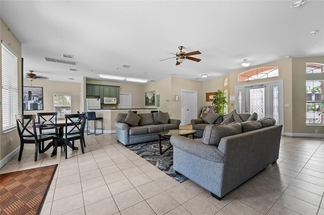 living room featuring ceiling fan, plenty of natural light, and light tile patterned flooring