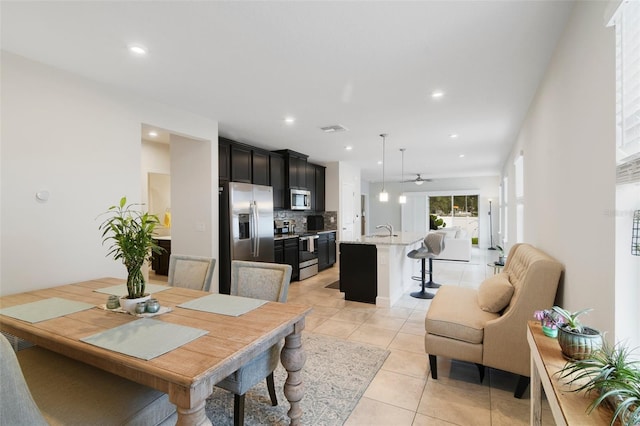 dining room with light tile patterned floors, sink, and ceiling fan