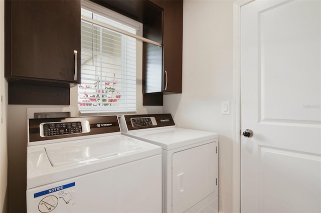 laundry area featuring cabinets, a wealth of natural light, and independent washer and dryer