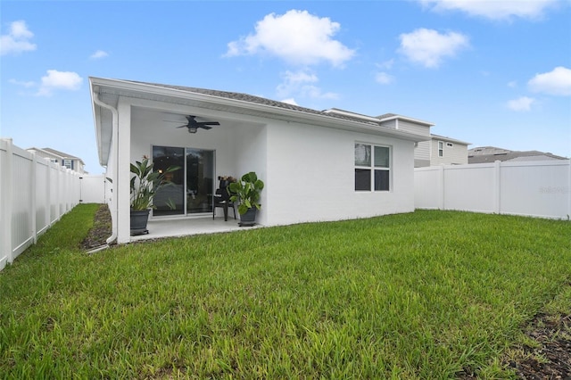 back of property featuring a lawn, ceiling fan, and a patio area