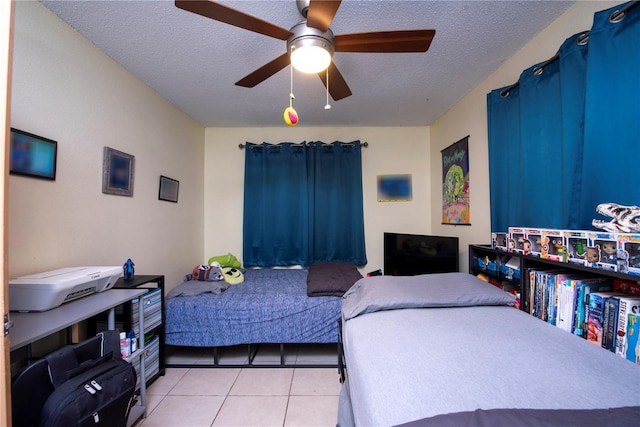 bedroom with ceiling fan, a textured ceiling, and light tile patterned floors