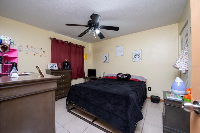 bedroom featuring ceiling fan, a textured ceiling, and light tile patterned floors