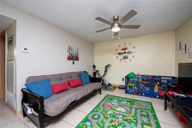 playroom featuring a textured ceiling, light tile patterned floors, and ceiling fan