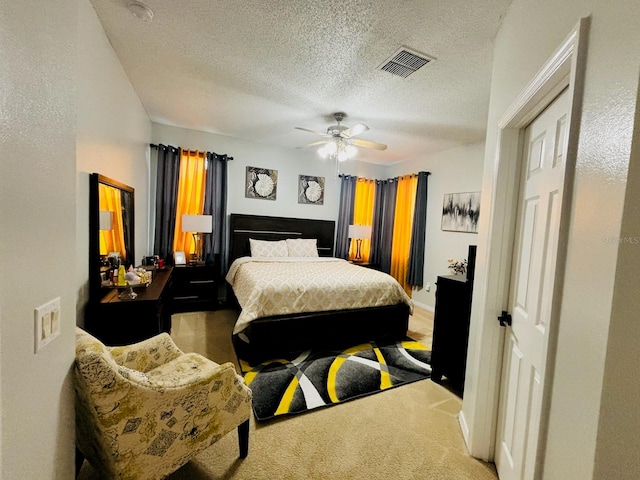 bedroom featuring a textured ceiling, ceiling fan, and carpet floors