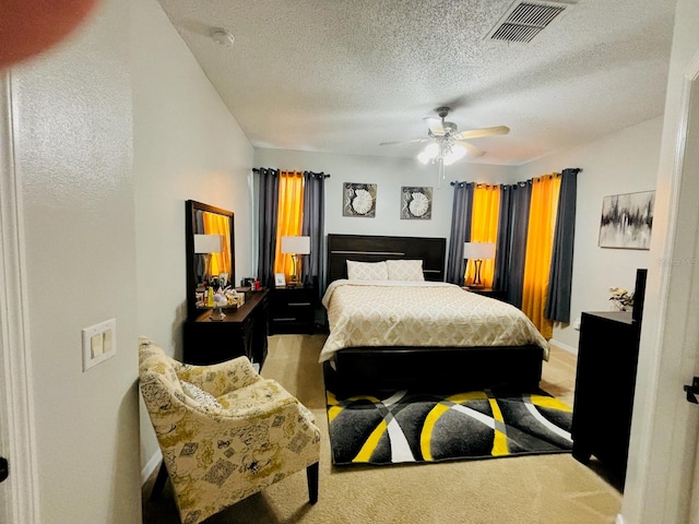 carpeted bedroom with ceiling fan and a textured ceiling