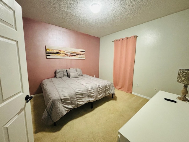 bedroom with light carpet and a textured ceiling