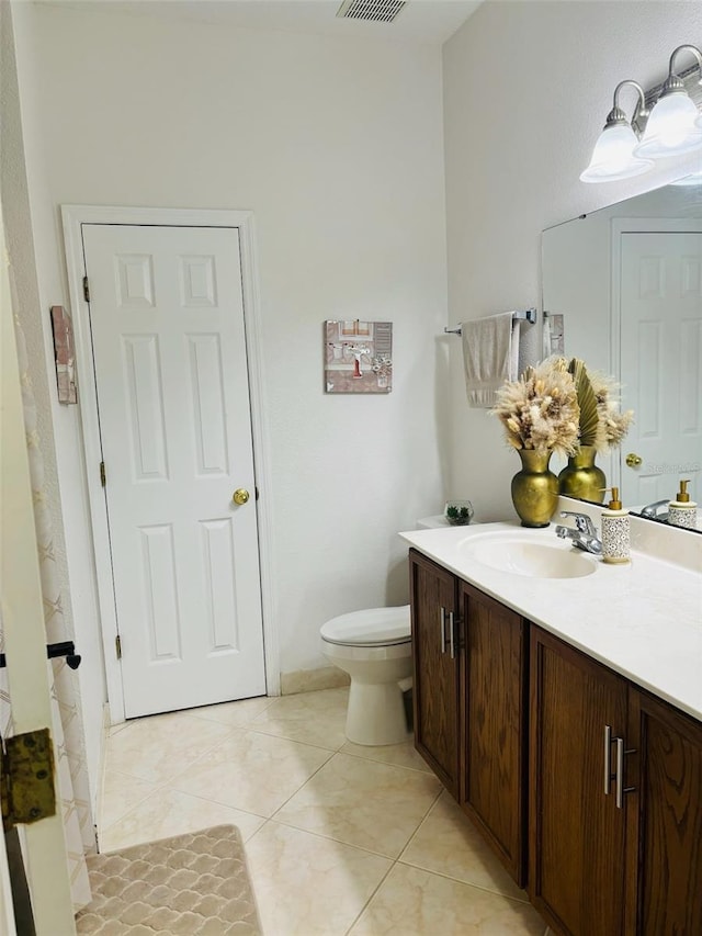 bathroom with tile patterned flooring, vanity, and toilet