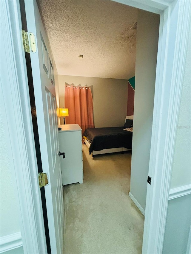 unfurnished bedroom with a textured ceiling and light colored carpet