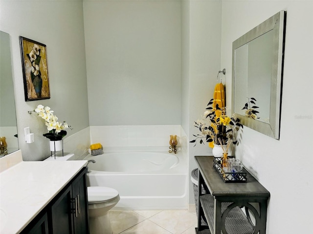 bathroom with tile patterned floors, a tub to relax in, vanity, and toilet