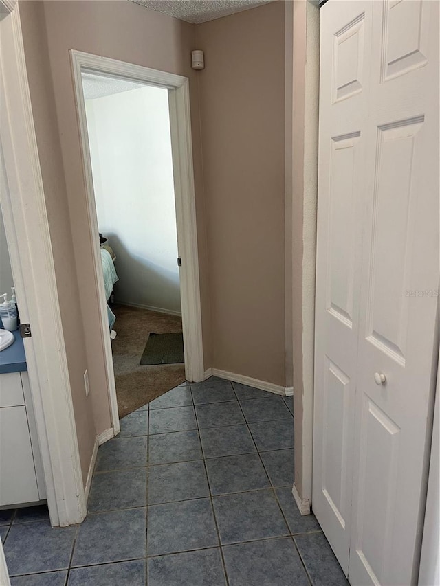 hallway featuring dark tile patterned floors