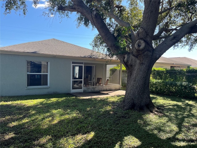 rear view of property featuring a lawn