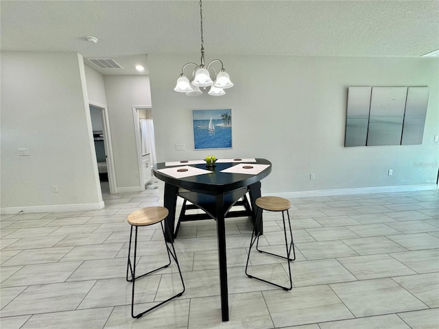 dining room featuring a notable chandelier and a textured ceiling