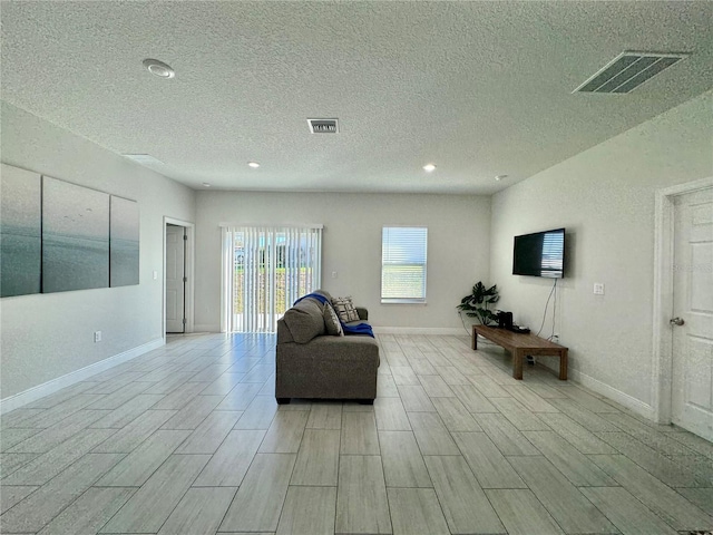 living room with a textured ceiling and light wood-type flooring