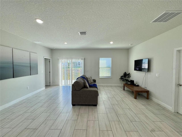 living room with light hardwood / wood-style floors and a textured ceiling