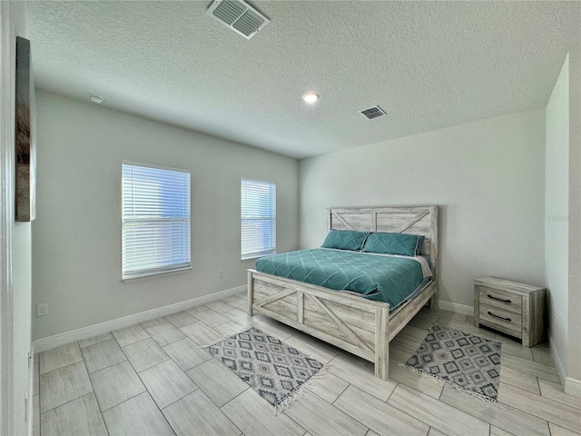 bedroom with light hardwood / wood-style flooring and a textured ceiling