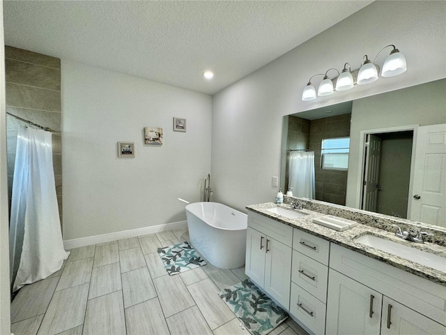 bathroom with vanity, a textured ceiling, and plus walk in shower