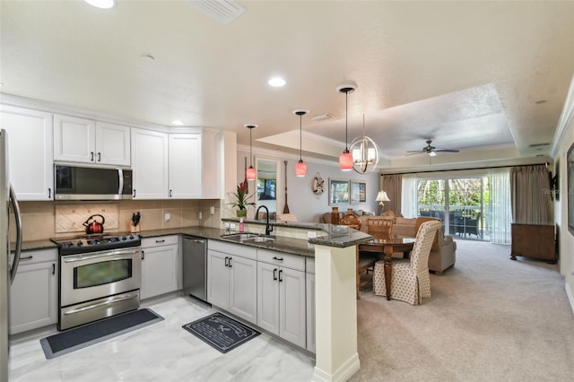 kitchen featuring white cabinetry, kitchen peninsula, appliances with stainless steel finishes, and sink