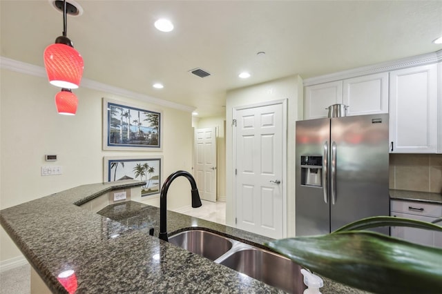 kitchen featuring stainless steel fridge, dark stone countertops, white cabinets, pendant lighting, and ornamental molding