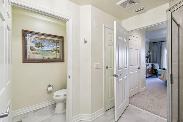 bathroom with a shower with door and toilet