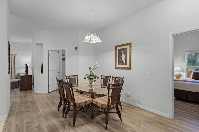 dining room with light hardwood / wood-style floors and an inviting chandelier