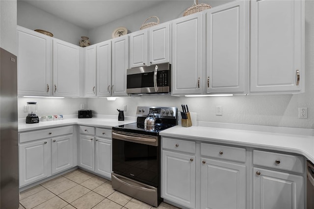 kitchen featuring light tile patterned flooring, stainless steel appliances, and white cabinetry