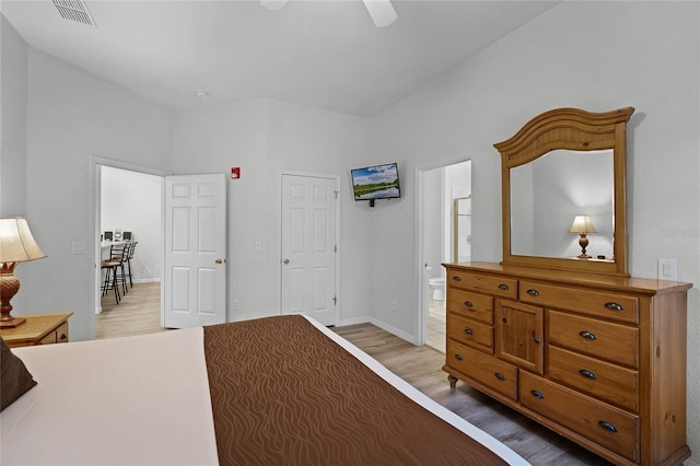 bedroom featuring light wood-type flooring, connected bathroom, and ceiling fan