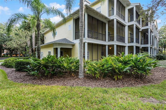 view of property exterior with a lawn and a balcony