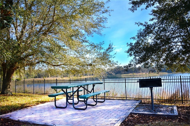 wooden deck with a patio and a water view