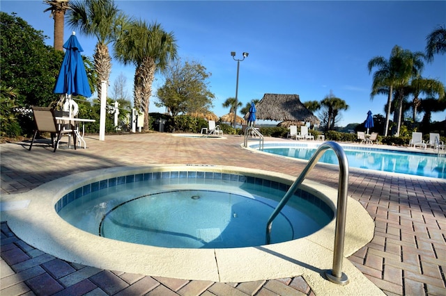 view of swimming pool featuring a community hot tub and a patio area