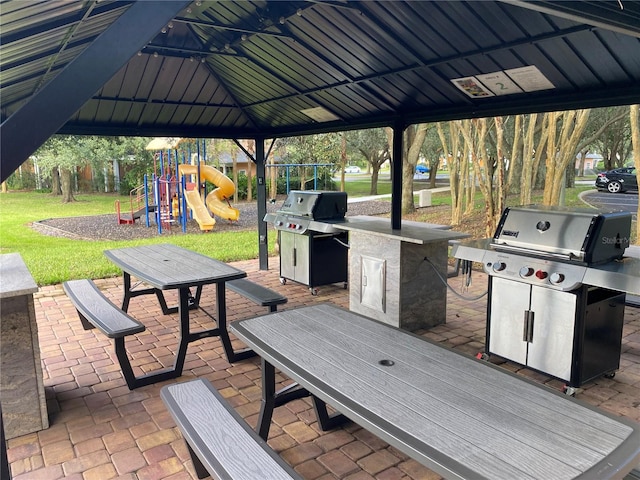 exterior space with a playground, a yard, a gazebo, grilling area, and a patio area