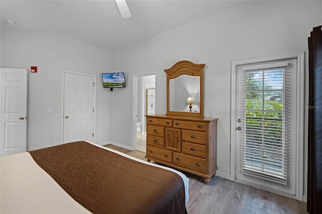 bedroom with access to outside, ceiling fan, light hardwood / wood-style floors, ensuite bathroom, and vaulted ceiling