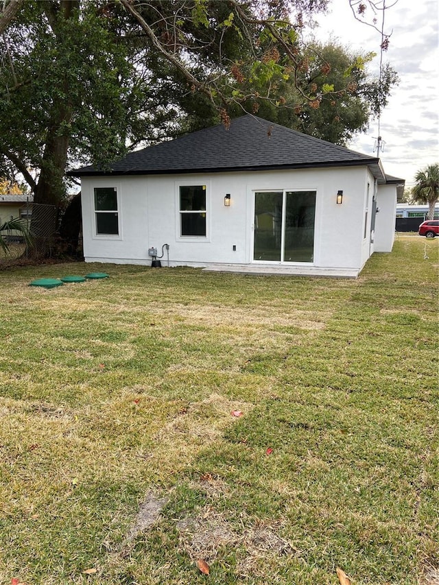 back of house featuring a lawn