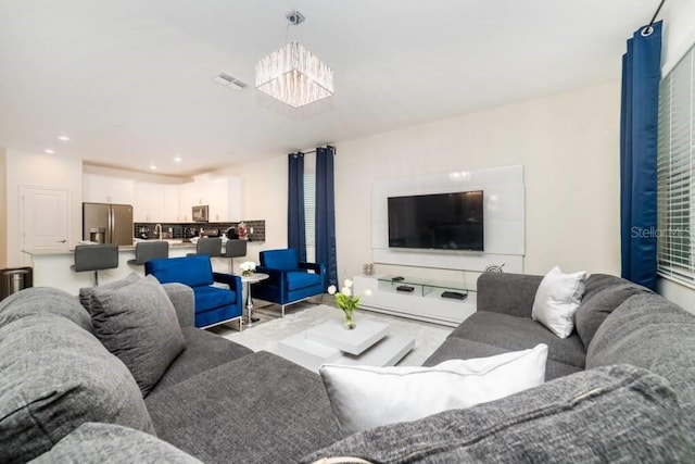 living area featuring recessed lighting, visible vents, and a chandelier