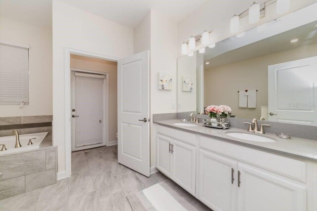 bathroom with a sink, a bath, and double vanity