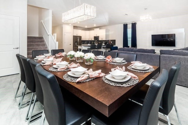 1676 Moon Valley Dr, Davenport, FL 33896 - dining space featuring recessed lighting, an inviting chandelier, marble finish floor, and stairs