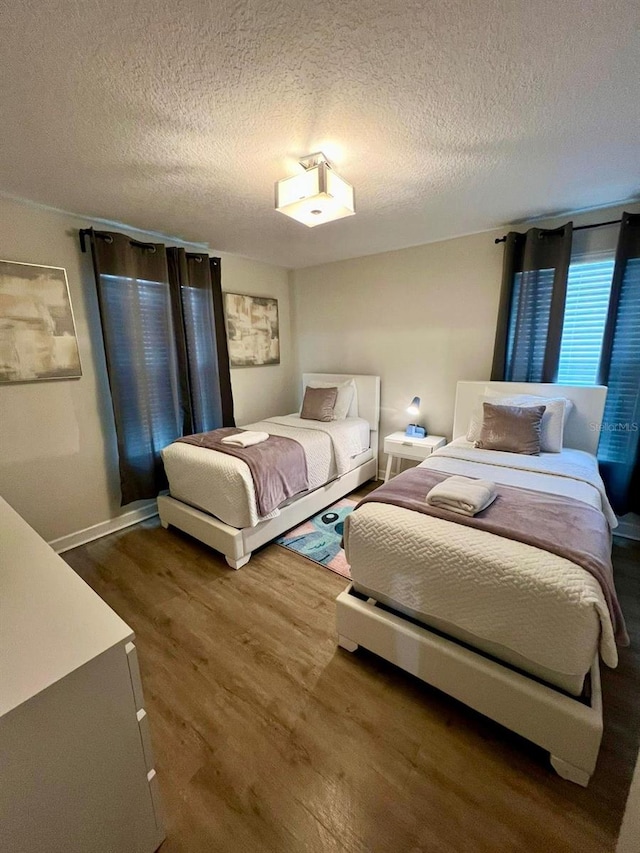 bedroom featuring a textured ceiling and wood finished floors